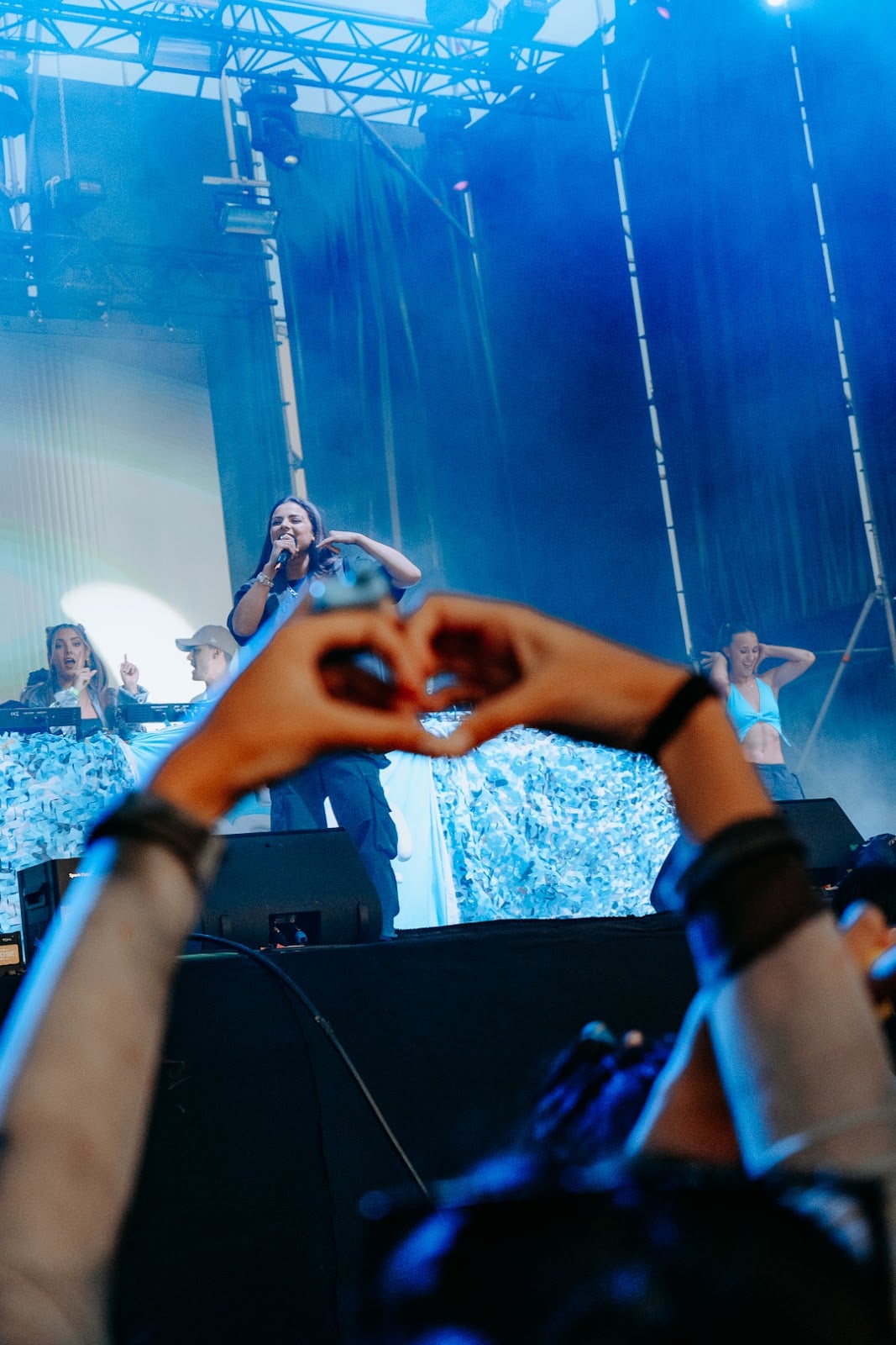 Singer performing on stage at Málaga Forum with audience hands in the foreground